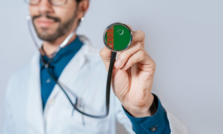 Doctor holding stethoscope with Turkmenistan flag. Turkmenistan health and care concept, Turkmenistan flag on stethoscopeの写真素材