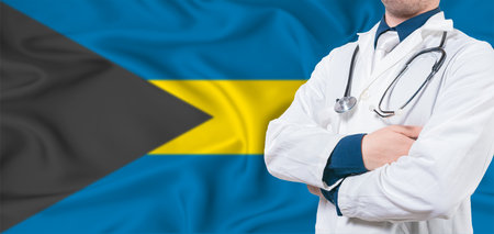 Bahamas healthcare concept. Male doctor on Bahamas flag. Doctor with crossed arms on Bahamas flagの写真素材