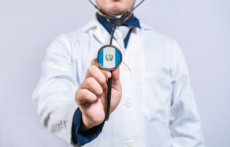 Doctor hands holding stethoscope with Guatemala flag. Guatemala health and care conceptの写真素材