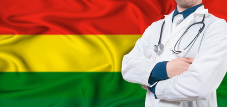 Bolivia healthcare concept. Male doctor on Bolivia flag. Doctor with crossed arms on Bolivia flagの写真素材