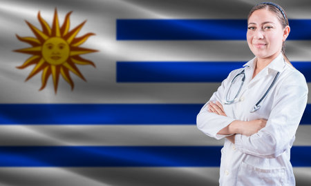 Female doctor on Uruguay flag. Doctor with crossed arms on Uruguay flag. Uruguay health and care conceptの写真素材