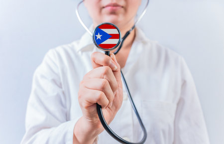 Female doctor holding stethoscope with Puerto Rico flag. National health system of Puerto Ricoの写真素材