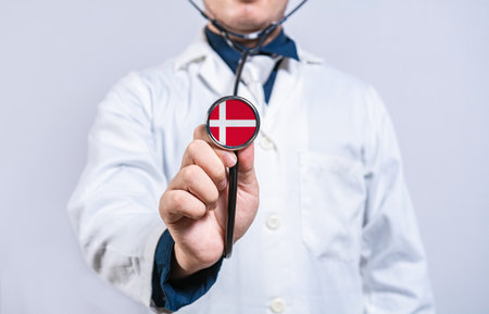 Doctor holding stethoscope with Danish flag. Denmark health and care conceptの写真素材