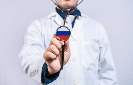 Doctor hands holding stethoscope with Russia flag. Russia health and care conceptの写真素材