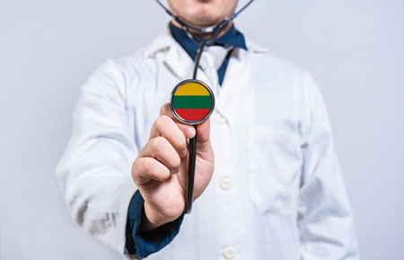 Doctor hands holding stethoscope with Lithuania flag. Lithuania health and care conceptの写真素材