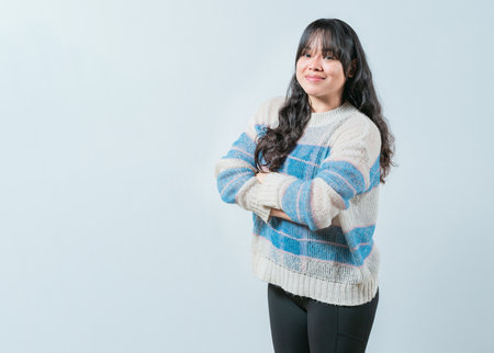 Portrait of beautiful and smiling Asian woman on isolated background. Young Asian female with crossed arms isolatedの写真素材