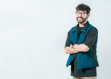 Smiling and handsome guy with glasses holding arms crossed isolated. Portrait of cool and handsome casual man with glasses and crossed armsの写真素材