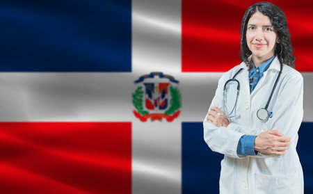 Dominican medicine and healthcare concept. Doctor close up against Dominican Republic flag backgroundの写真素材