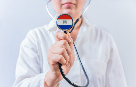Female doctor holding stethoscope with Paraguay flag. National health system of Paraguayの写真素材