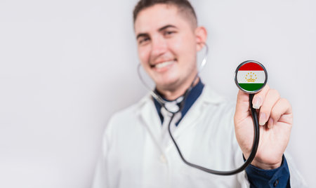 Doctor showing stethoscope with Tajikistan flag. Tajikistan national healthcare conceptの写真素材