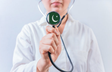 Female doctor holding stethoscope with Pakistan flag. National health system of Pakistanの写真素材
