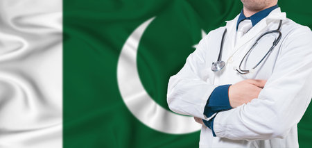 Pakistan healthcare concept. Male doctor on Pakistan flag. Doctor with crossed arms on Pakistan flagの写真素材