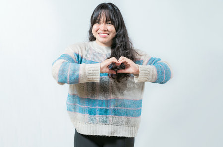 Beautiful asian girl making heart shape isolated. Happy asian woman making heart shape with handsの写真素材