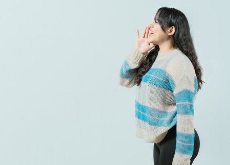 Young woman shouting an announcement. Beautiful girl shouting isolatedの写真素材