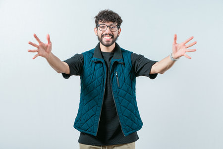 Friendly guy welcoming with open arms isolated. Cheerful young man welcoming you with open armsの写真素材