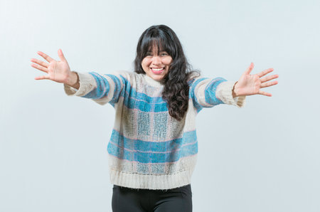 Friendly asian girl welcoming with open arms isolated. Beautiful asian woman welcoming you with open armsの写真素材