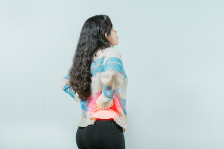 Lumbar problems. woman with pain holding her back. Suffering young woman with pain holding her back...