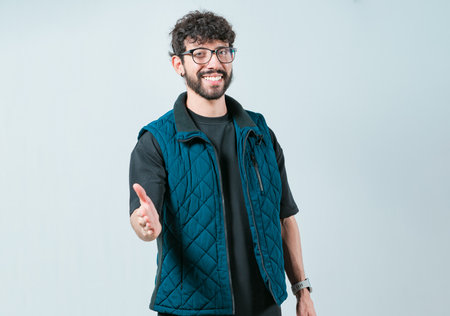 Friendly handsome guy greets you with open hand isolated. Male person extending his hand to the camera welcoming youの写真素材