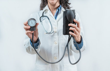 Doctor hands showing blood pressure monitor isolated. Close up of Doctor showing tensiometer isolatedの写真素材