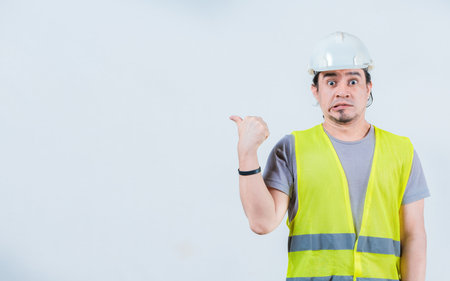 Surprised builder pointing at an isolated blank space. Amazed construction worker pointing at an...