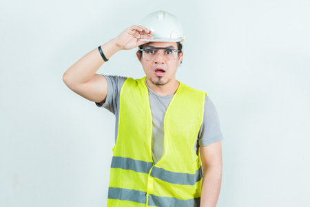 Surprised engineer looking into the distance isolated. Amazed engineer looking into the distance. Young engineer looking awayの写真素材