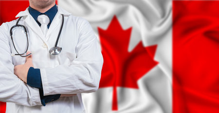 Male doctor with stethoscope on Canada flag. Doctor holding stethoscope on Canadian flagの写真素材