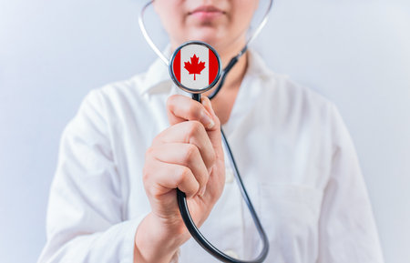 Female doctor holding stethoscope with Canada flag. National Health System of Canadaの写真素材