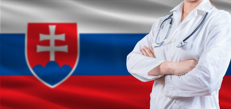 Doctor with crossed arms on Slovakian flag. Slovakia health and care concept. Female doctor on Slovakian flagの写真素材
