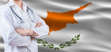 Doctor with crossed arms on Cyprus flag. Cyprus health and care concept. Female doctor on Cyprus flagの写真素材