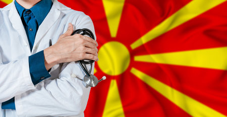 Doctor with stethoscope on North Macedonia flag. Doctor holding stethoscope on North Macedonia flagの写真素材