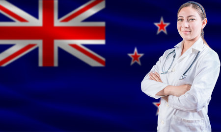 Female doctor on New Zealand flag. Doctor with crossed arms on New Zealand flag. New Zealand health and care conceptの写真素材