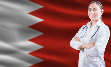 Female doctor on Bahrain flag. Doctor with crossed arms on Bahrain flag. Bahrain health and care conceptの写真素材