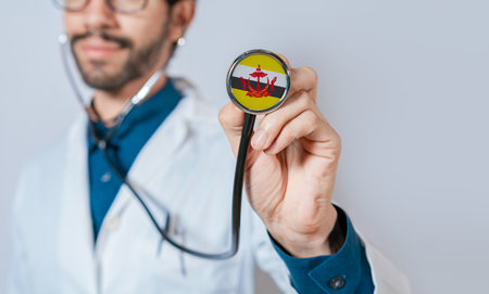 Doctor holding stethoscope with Brunei flag. Brunei health and care concept, Brunei flag on stethoscopeの写真素材