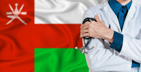 Doctor with stethoscope on Oman flag. Doctor holding stethoscope on Oman flagの写真素材