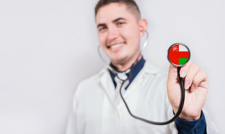 Doctor showing stethoscope with Oman flag. Oman national healthcare conceptの写真素材