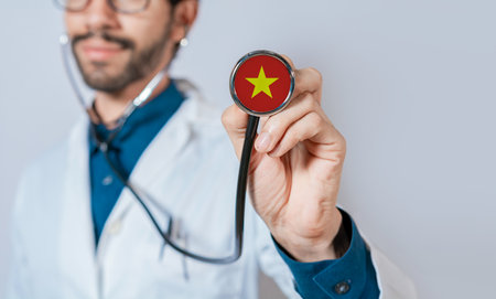 Doctor holding stethoscope with Vietnam flag. Vietnam health and care concept, Vietnam flag on stethoscopeの写真素材