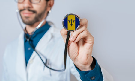 Doctor holding stethoscope with Barbados flag. Barbados health and care concept, Barbados flag on stethoscopeの写真素材