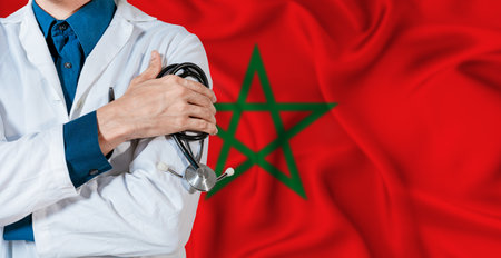 Morocco healthcare concept. Doctor with stethoscope on Morocco flag. Doctor holding stethoscope on Moroccan flagの写真素材