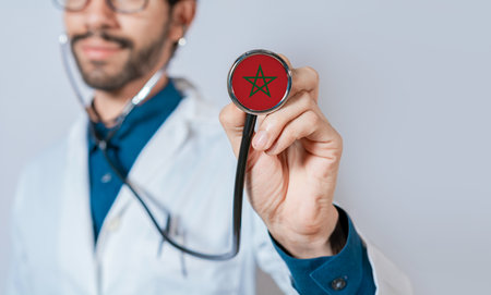 Doctor holding stethoscope with Morocco flag. Morocco health and care concept. Morocco flag on stethoscopeの写真素材