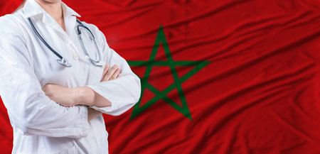 Doctor with crossed arms on Morocco flag. Moroccan health and care concept. Female doctor on Morocco flagの写真素材