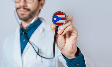 Doctor holding stethoscope with Puerto Rico flag. Puerto Rico health and care concept. Puerto Rico flag on stethoscopeの写真素材
