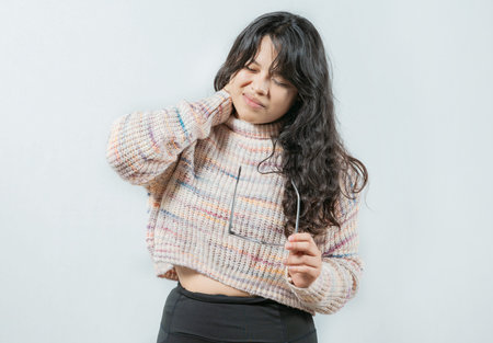 Stressed young woman holding her glasses, isolated, eye strain