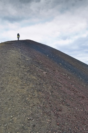 Walker at top of volcanic mountain in Jokulsargljufur National Park (Iceland)の写真素材