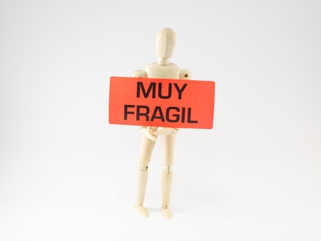 articulated wooden dummy holding a sticker that gets very fragile, isolated on white backgroundの写真素材