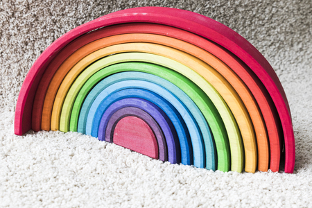 waldorf rainbow colored wood on white carpetの写真素材