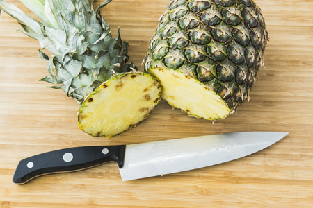closeup cutting a natural pineapple on wooden backgroundの写真素材