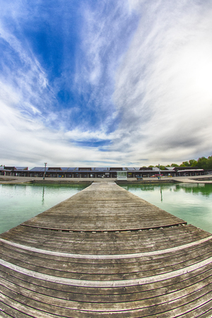 A wooden pier on a Lake regatta with blue skyの写真素材