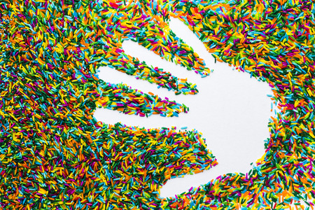 A Hand Copyspace on colorful rice on white background