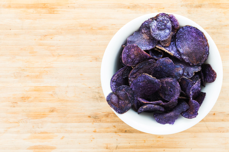 A Heap of purple potato chips on wooden backgroundの写真素材