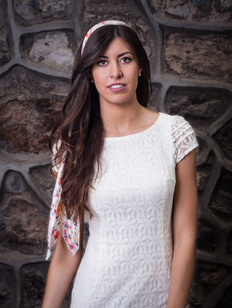 A pretty brunette girl with brick wall backgroundの写真素材